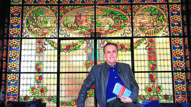 Juan Cobos Wilkins, con su último poemario en la mano, en el Palacio Mora Claros de Huelva.