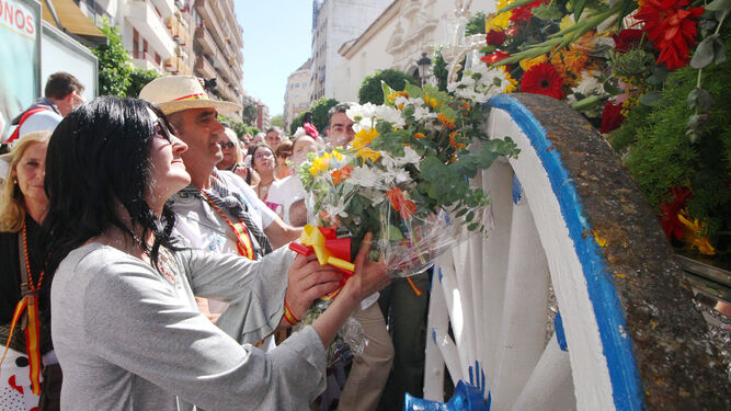 La jefa de sección de 'Huelva Información' Ana Vives, entrega un ramo de flores a Emigrantes.