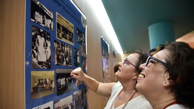Dos mujeres observan uno de los paneles de la muestra fotográfica sobre los 40 años del hospital, ayer.