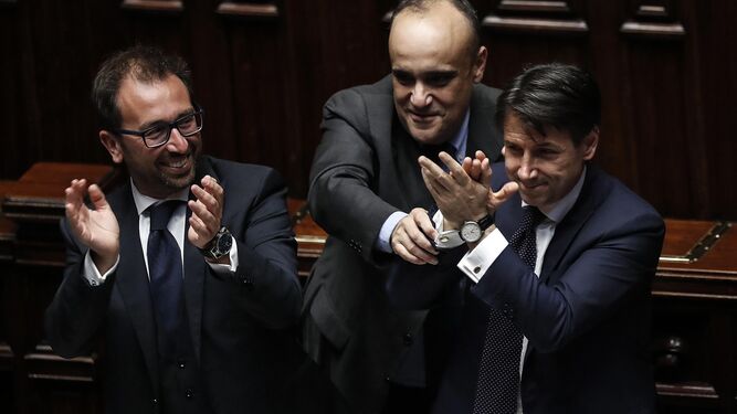 Giuseppe Conte (derecha) celebra ayer junto a los ministros Riccardo Fraccaro (i) y Alfonso Bonafede (c) su investidura como nuevo primer ministro italiano.