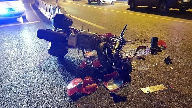 La moto tirada en el asfalto tras el accidente.