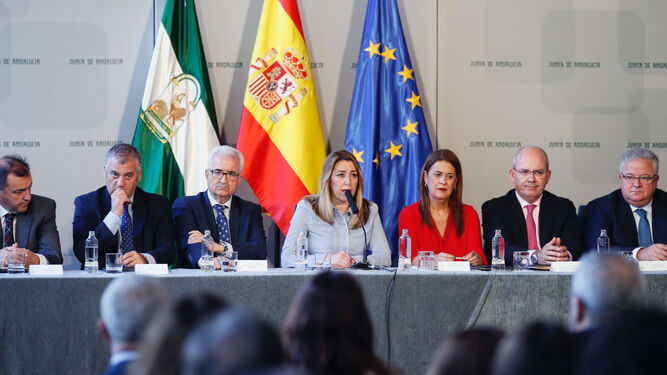 Susana Díaz, en el centro, junto a otras autoridades y empresarios de la estiba tras la firma del convenio