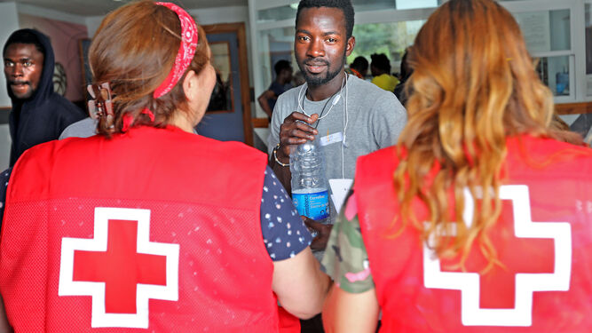 Una de las personas atendidas en el Kiko Narváez, junto a dos voluntarias de Cruz Roja.