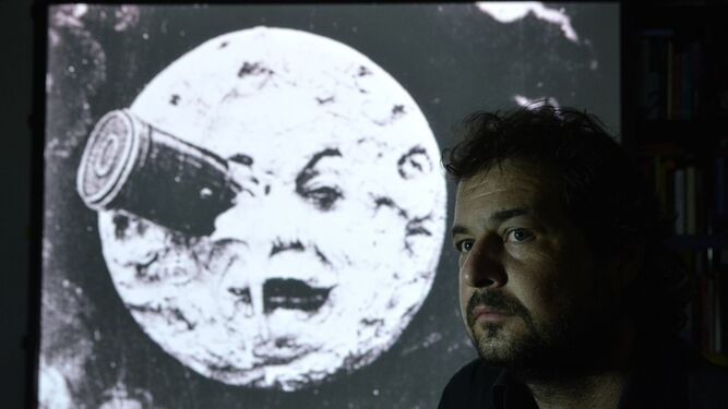 David Eloy Rodríguez (Cáceres, 1976), junto a una de las imágenes icónicas del largometraje de Méliès 'Viaje a la luna'.