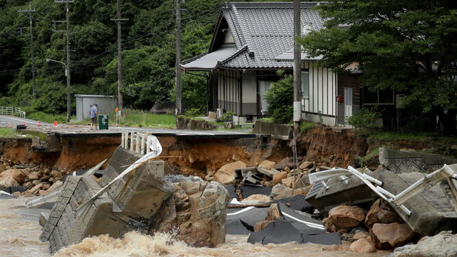 Un hombre observa los destrozos ayer en una carretera en la prefectura de Hiroshima.
