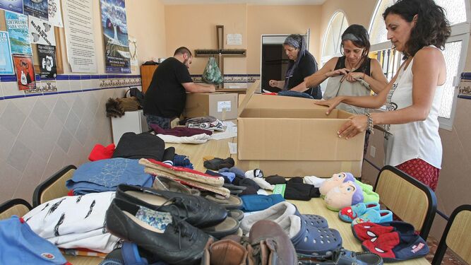 Voluntarios preparan ropa donada para los migrantes en la parroquia de Pescadores, ayer.