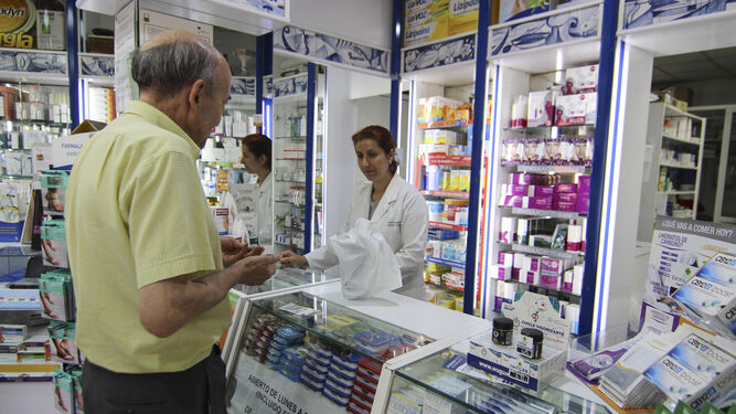 Un hombre compra medicamentos en una farmacia.