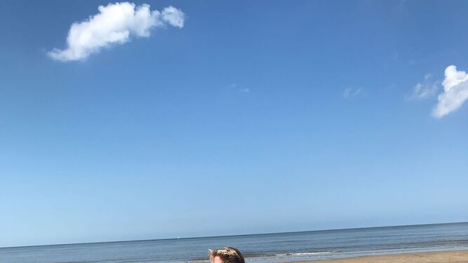 Una mujer con su perro, en la playa.