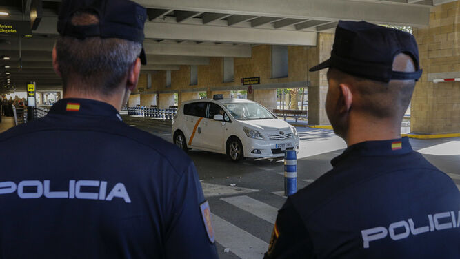 El Consistorio se ha personado recientemente en la macrocausa de la mafia del taxi a través de la empresa Tussam. En la imagen, dos policías en la parada de taxis del aeródromo sevillano.
