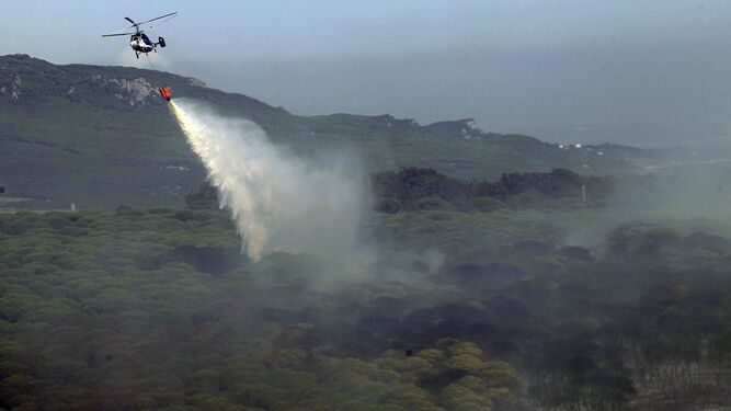 Un helicóptero lucha contra el incendio forestal declarado en Bolonia.