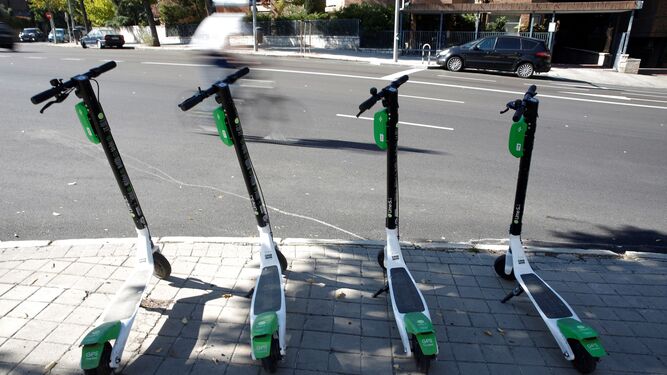 Cuatro patinetes eléctricos aparcados en una calle de Madrid.