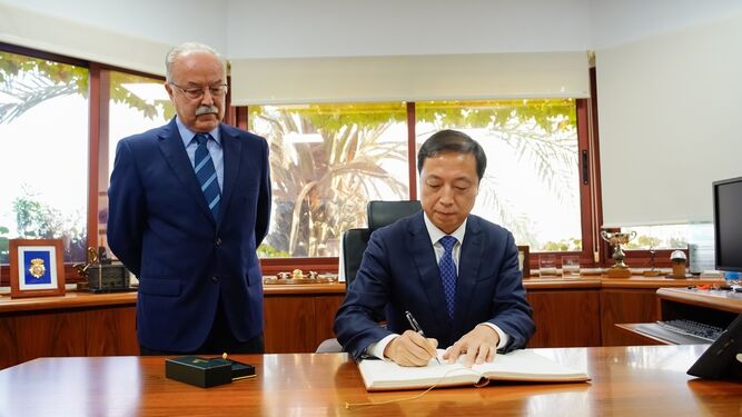 Mao Jianhong firma en el libro de honor de la APBA junto a Manuel Morón