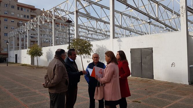 Concejales de Ciudadanos y representantes de la asociación de vecinos Andalucía junto al pabellón sin terminar.