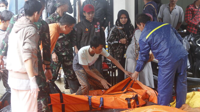 Los servicios de emergencia recogen los cuerpos de los fallecidos en el tsunami.