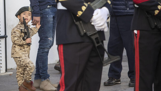 Un pequeño vestido como un soldado,  pendiente de las fuerzas formadas en la Pascua Militar.