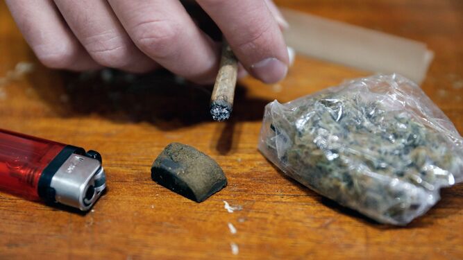 Un consumidor de cannabis, con una piedra de hachís y una bolsa de marihuana.