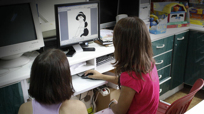 Dos menores juegan con una aplicación infantil en un ordenador.