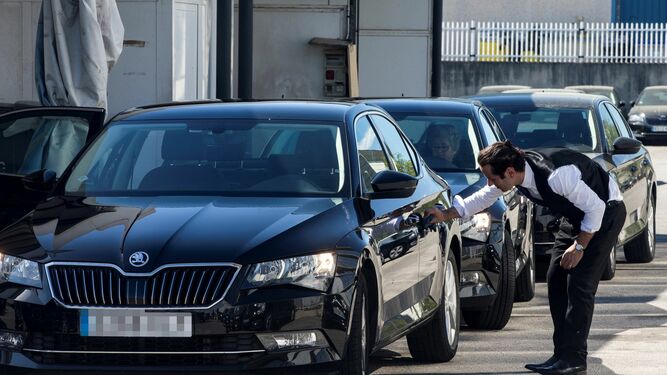 Un conductor de Cabify limpia su vehículo en Barcelona.