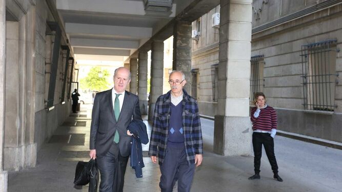 El ex viceconsejero de Empleo Justo Mañas, a la derecha, con su abogado, Miguel Cuéllar, en los juzgados de Sevilla.