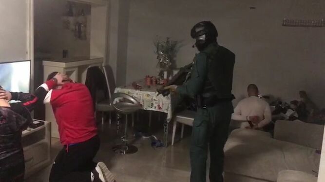 Un agente de la Guardia Civil custodia a varios detenidos en la Operación Trapera
