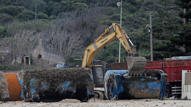 La empresa de las mejilloneras retira las estructuras varadas en la playa de Getares.