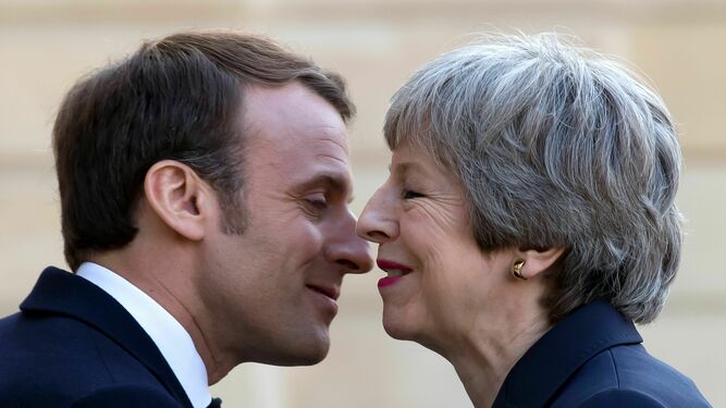 Macron y May se besan a las puertas del Elíseo en París.
