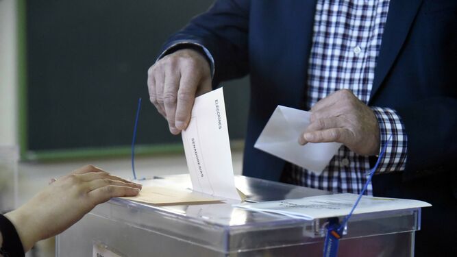 Un ciudadano deposita sus votos en las urnas.