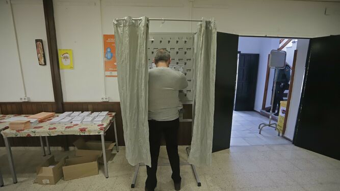 Una persona elige su voto en una cabina.