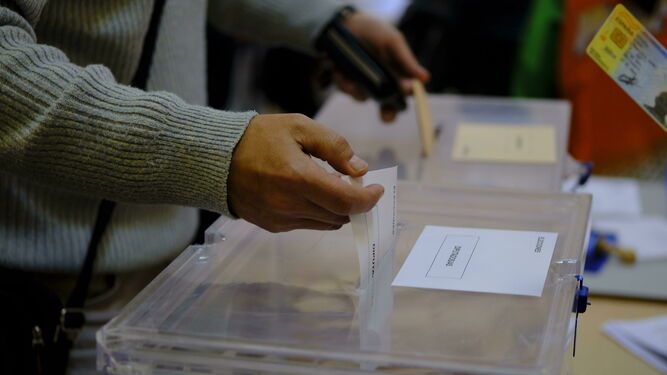 Un hombre deposita su voto en una urna.