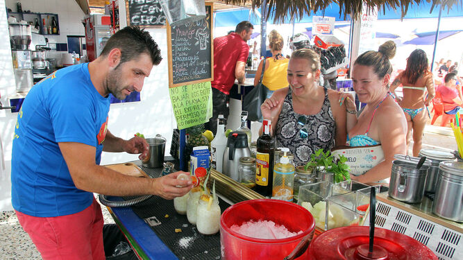Un camarero sirve a unas clientas en un chiringuito de Punta Umbría.