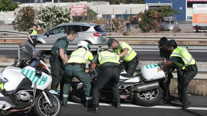 Varios compañeros de Fermín Cabezas levantan de la calzada su motocicleta.