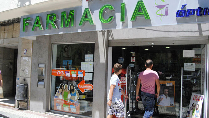 Dos usuarios entran en una oficina de farmacia de Huelva.