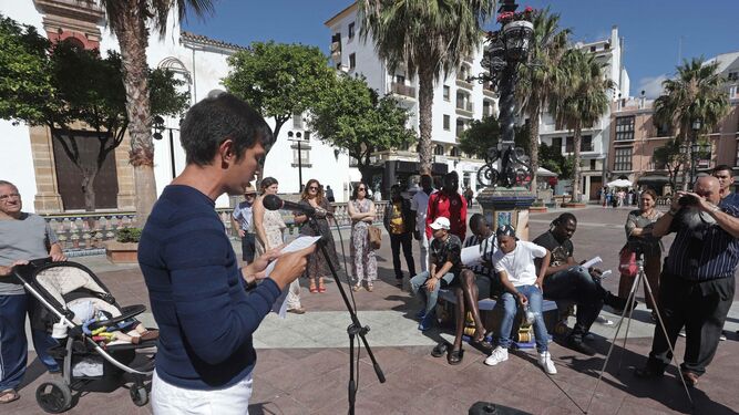 Una persona lee el manifiesto del Día Internacional de las Personas Refugiadas en la Plaza Alta de Algeciras.