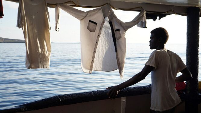Un migrante en la cubierta del buque Open Arms frente a las costas de Lampedusa.