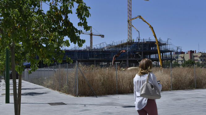 Una mujer pasea junto a una parcela destinada a vivienda protegida en Sevilla