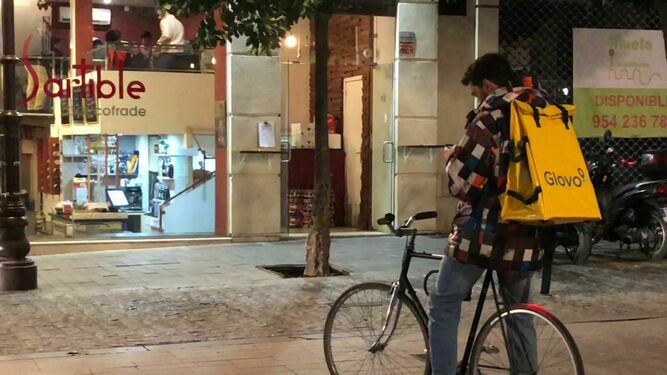 Un repartidor en bicicleta consulta su móvil.
