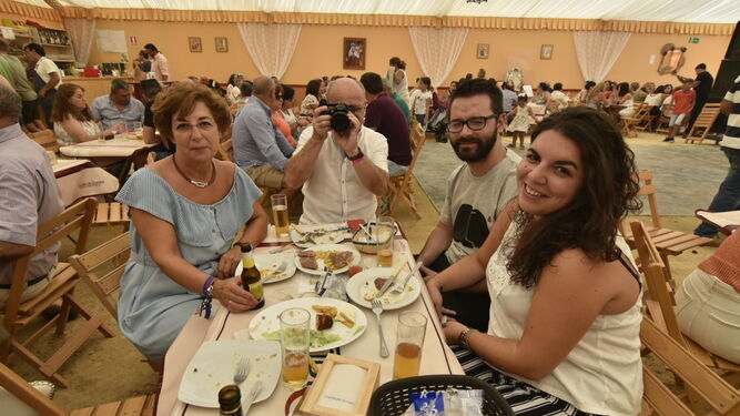 Cuatro personas almuerzan en una de las casetas de la Feria de Tarifa.