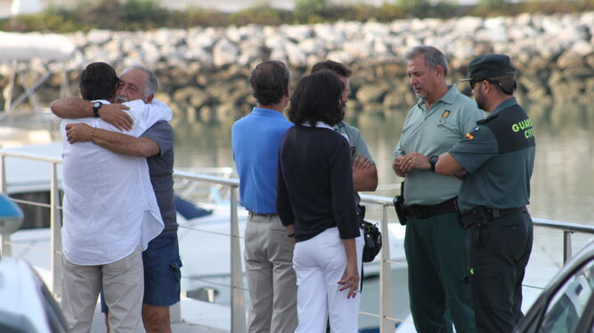 Familiares de Luis se abrazan en el puerto de Barbate, junto a los agentes que han trabajado en el dispositivo.