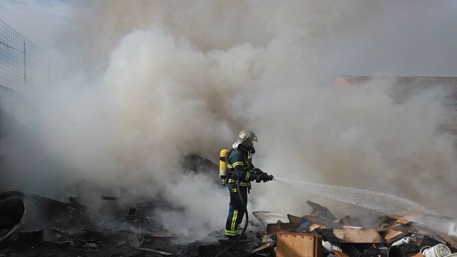 Un bombero actúa en el incendio de un local en La Línea