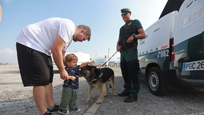 Un niño juega con un perro de la Guardia Civil.