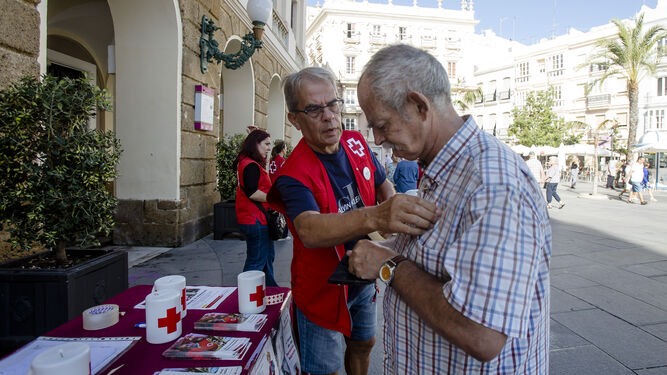 Un señor colaborando con Cruz Roja en la plaza de San Juan de Dios.