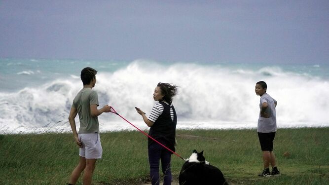 Varias personas observan las olas gigantes causadas por el tifón en Atawa.