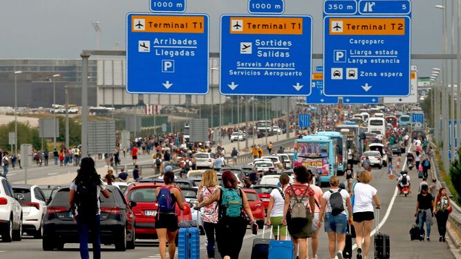 Viajeros llegan al Prat a pie tras la llamada a paralizar los accesos al aeropuerto.