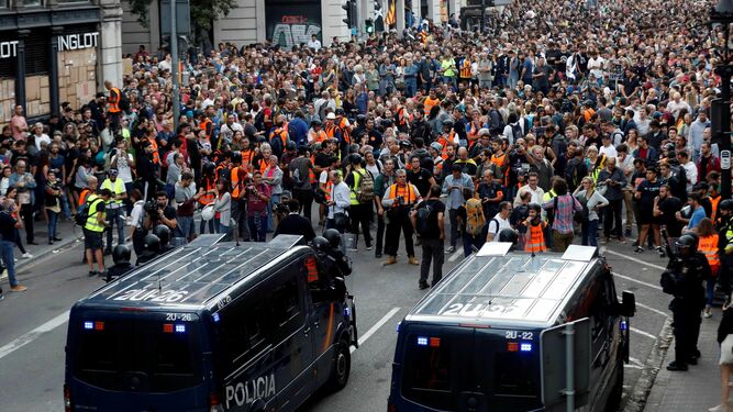 Manifestantes ante  furgones de la Policía Nacional en la Vía Laietana.
