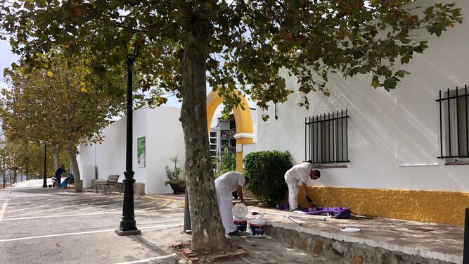 Dos pintores adecentan la entrada al cementerio de Los Barrios.