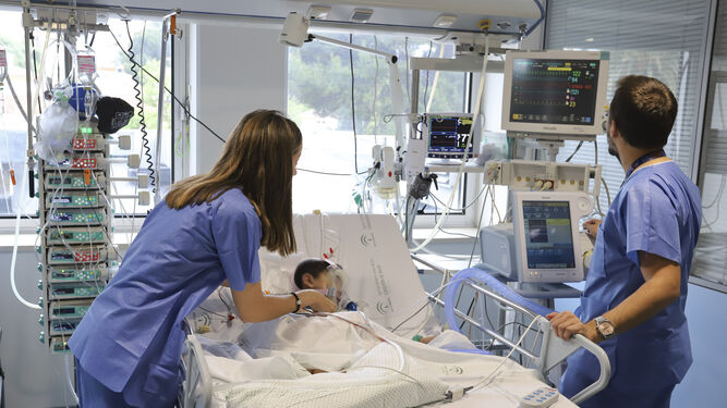 Dos enfermeros controlan el estado de un paciente.