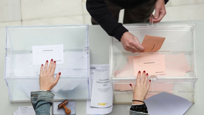 Un votante deposita su sobre en una mesa electoral