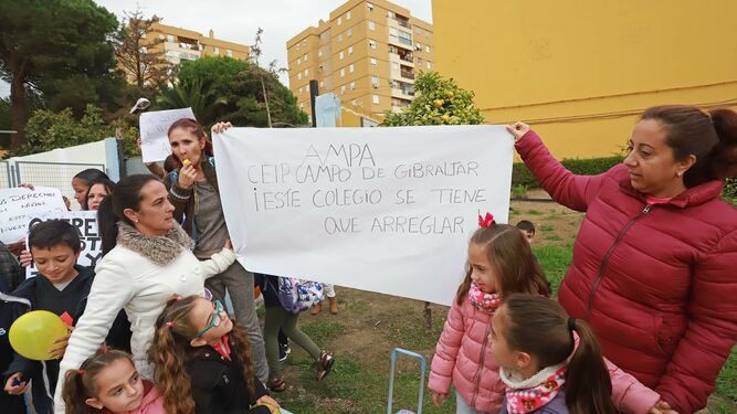 Madres sostienen una pancarta en la puerta del colegio Campo de Gibraltar, en Algeciras.