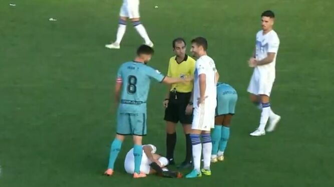 El capitán algecireño Iván habla con el árbitro y un jugador del Marbella.