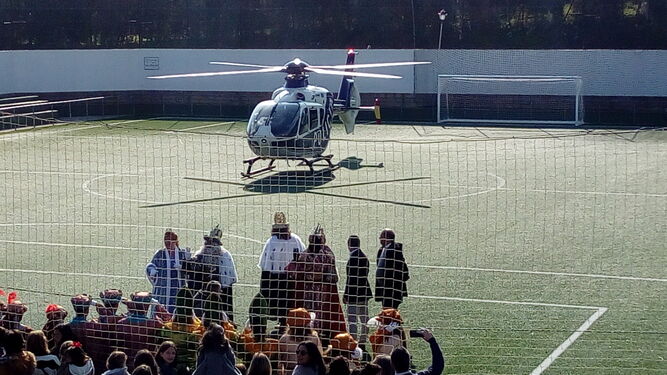 Sus Majestades, junto al alcalde, despiden el helicóptero que les trasladó hasta el polideportivo.